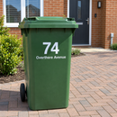 Personalised wheelie bin sticker on a green bin outside a new-build house