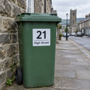 Personalised wheelie bin sticker on a green bin in a market town