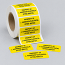 Roll of yellow personalised tool labels printed Property Of with a name and phone number