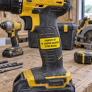 Yellow name label on a cordless drill handle in a workshop