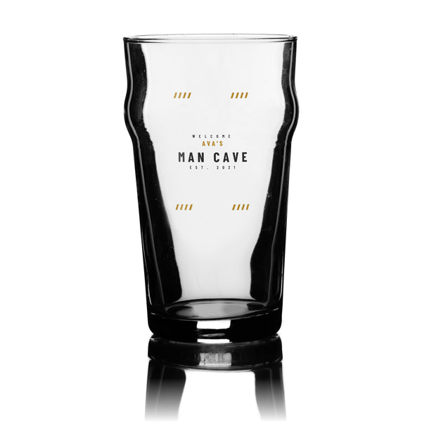 Personalised man cave pint glass with a gold and charcoal Welcome, name and Man Cave design, UV DTF printed on a clear 20oz nonic pint glass
